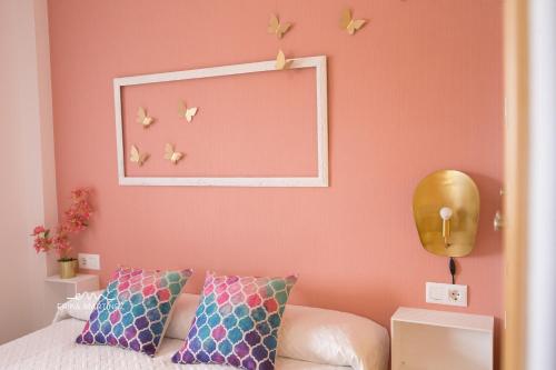 巴尔巴特MRZ Rentals Barbate Playa的卧室设有粉红色的墙壁、一张床和镜子