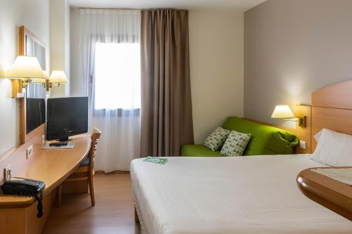 阿尔卡拉德荷那利斯Travelodge Madrid Alcalá de Henares的酒店客房配有一张床和一张带电脑的书桌