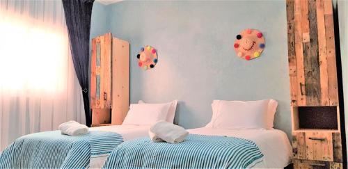 达赫拉Dakhla Ride Adventures的蓝色墙壁客房中的两张单人床