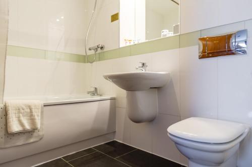 普雷斯顿传统普雷斯顿国际酒店的白色的浴室设有水槽和卫生间。