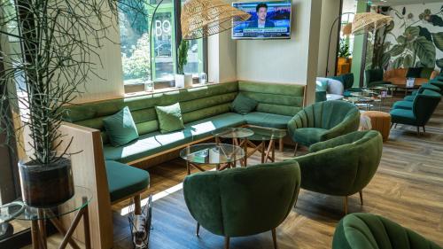 尼奥尔尼奥尔马莱波特温美居酒店的一间设有绿色沙发和椅子的等候室