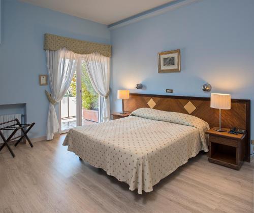 弗拉斯卡蒂卡夏尼酒店的一间卧室设有一张床和一个大窗户