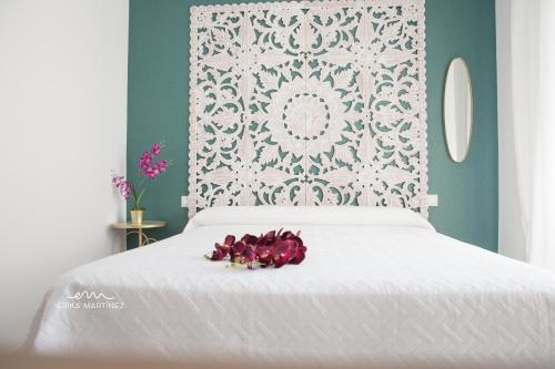 巴尔巴特MRZ Rentals Barbate La Fábrica的一张白色的床,上面有一堆鲜花