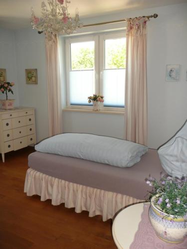 奥斯特西巴德钦诺维茨Gästehaus Grothe的一间卧室设有一张床和两个窗户。