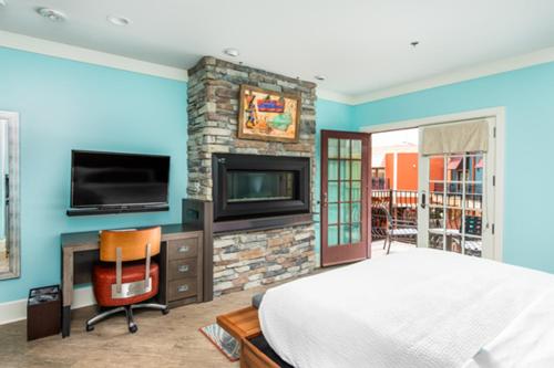 鸽子谷玛格丽塔岛酒店的一间卧室配有一张床、一个壁炉和一台电视。