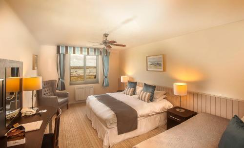 瓦利半岛酒店 的酒店客房配有床、沙发和电视。