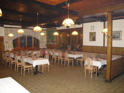 Hirschegg Rein海尔施格尔霍夫酒店的用餐室配有白色的桌椅和灯光