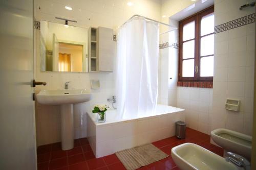 波贾尔多Villa Topazio的带浴缸、水槽和镜子的浴室