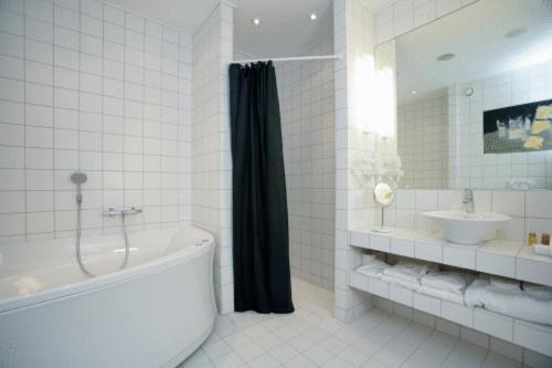 斯劳厄尔瑟OnlySleep Oksebrovej的白色的浴室设有浴缸和水槽。