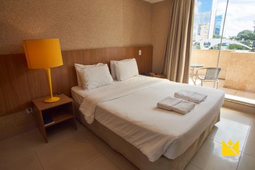 巴西利亚巴西利亚帝国酒店的一间卧室配有一张带灯和窗户的床