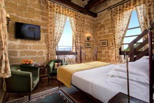马尔萨拉Hotel Baglio Oneto dei Principi di San Lorenzo - Luxury Wine Resort的一间卧室设有一张床、一台电视和窗户。