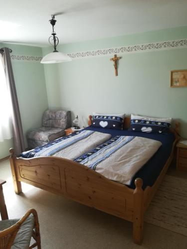 莫斯巴赫Hanslbauernhof的卧室内的一张床铺,墙上有十字架
