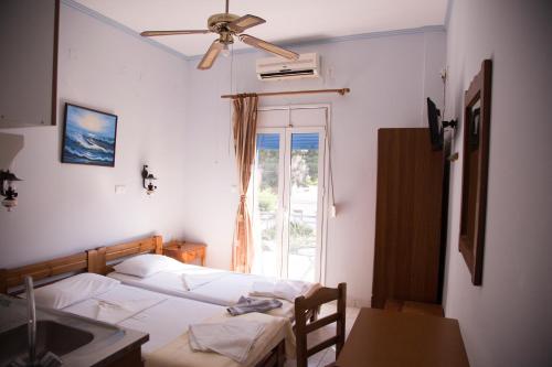 阿基奥斯基利考斯Hotel Asteria的一间卧室配有一张带吊扇和窗户的床。