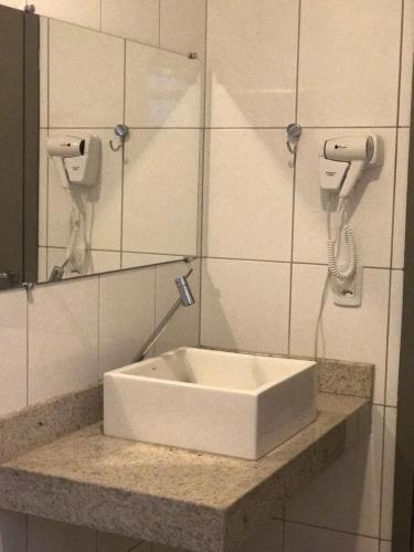 阿拉瓜伊纳Oásis Hotel的浴室设有白色水槽和镜子