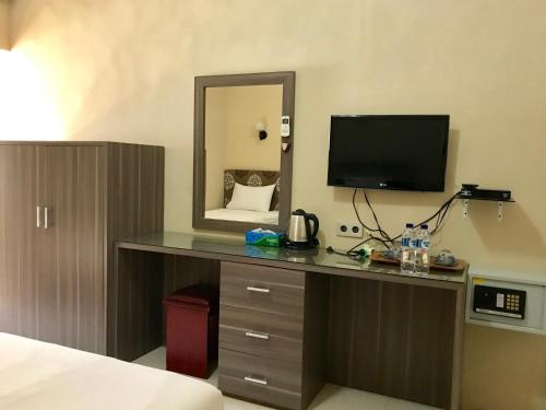 沙璜安诺伊艾塔姆度假酒店的客房设有一张带电视和镜子的书桌。