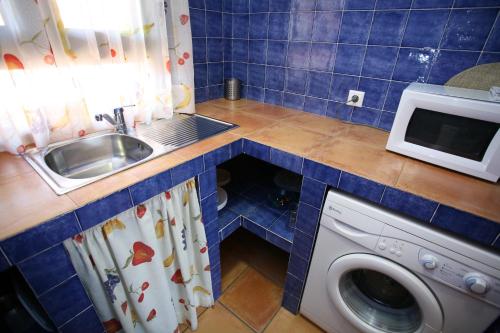 CorduenteCASA RURAL MIRALTAJO的一个带水槽和洗衣机的小厨房