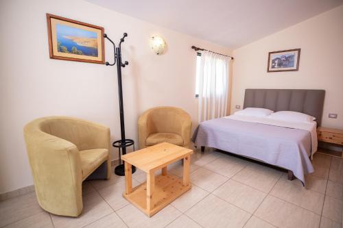 德尔米Chalet Ambel的一间卧室配有一张床、两把椅子和一张桌子