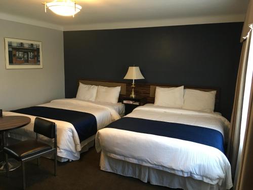 尼亚加拉瀑布瀑布庄园度假酒店的酒店客房设有两张床和一张带台灯的桌子。