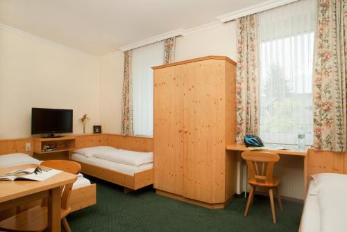 Bad FischauHubertushof Fromwald Hotel und Gasthof的酒店客房设有一间带一张床和电视的卧室