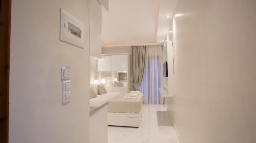 帕拉塔蒙Amaryllis Luxury Rooms的白色的客房配有床和镜子
