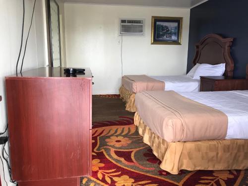 大西洋城日落汽车宾馆的酒店客房设有两张床和一张桌子。