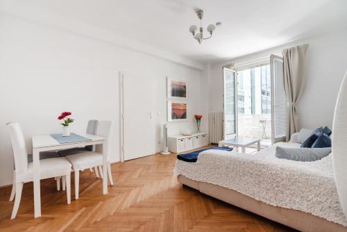 维也纳阿尔加维市中心奥佩拉大街公寓的白色卧室配有桌子和床