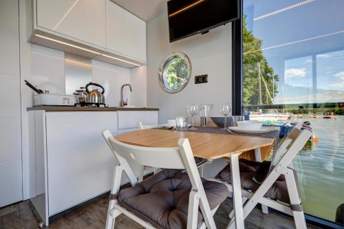 鲁恰内尼达Apartament Na Wodzie的厨房以及带木桌和椅子的用餐室。