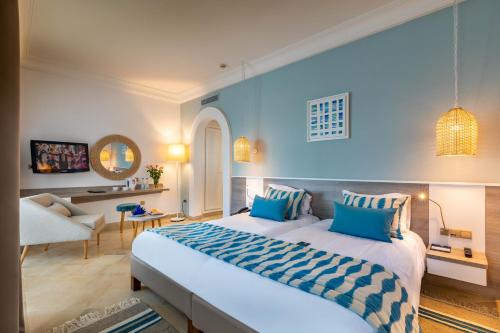 乌姆苏克Ulysse Djerba Thalasso & SPA的一间带大床的卧室和一间客厅