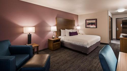 拉皮德城Best Western Plus Rapid City Rushmore的配有一张床和一把椅子的酒店客房