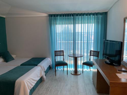 托米尼奥努埃瓦科利纳酒店的酒店客房带一张床、一张桌子和椅子