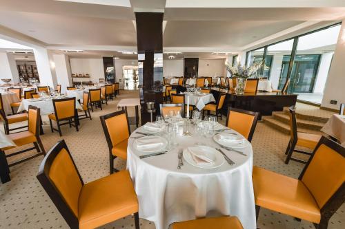 马马亚Alcor Beach Hotel的用餐室配有桌椅和白色桌布
