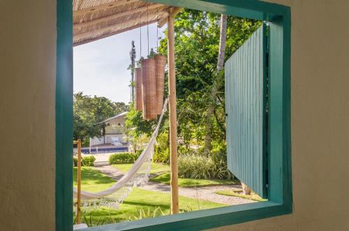 托兰克索Pousada Villa Bahia的窗户配有吊床,眺望着庭院