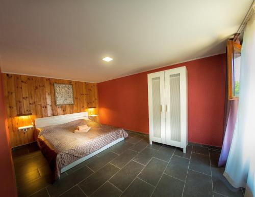 希科尔皮诺夫西Alexander的卧室设有红色的墙壁和一张床