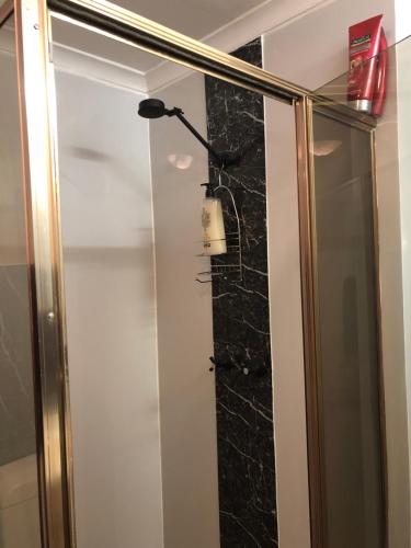库伯佩迪The Blacklighters Opal Retreat-Undergound的墙上设有灯光淋浴的浴室