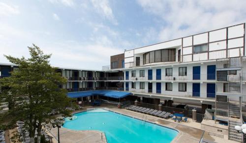 怀尔德伍德布列塔尼汽车旅馆 的大楼前设有游泳池的酒店
