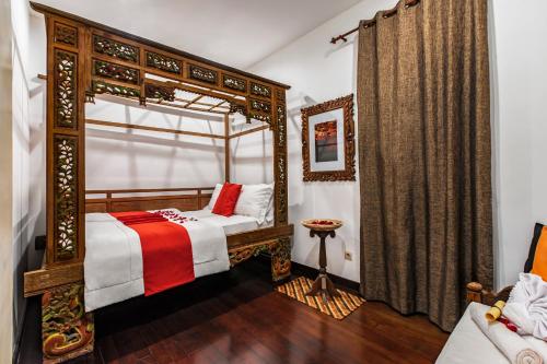 巴图Villa Mulyono 2的一间卧室配有天蓬床和沙发
