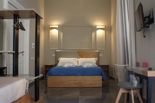 那不勒斯Be Italian Flat Piazza Bovio 22的一间卧室配有一张带蓝色床单和白色枕头的床。