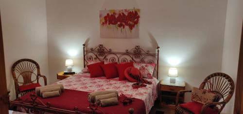 圣卡塔尔多La casa di Flora的一间卧室配有红色的床和两把椅子