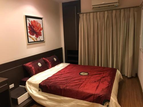 芭东海滩Phuket villa best location pool view的一间卧室配有一张红色棉被的床
