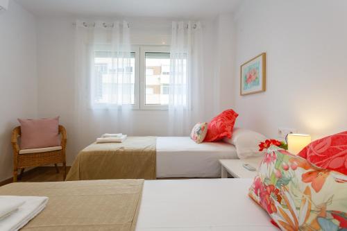 加的斯Casa Ros-PLAYA free parking by Cadiz4Rentals的白色的客房配有两张床和一张沙发