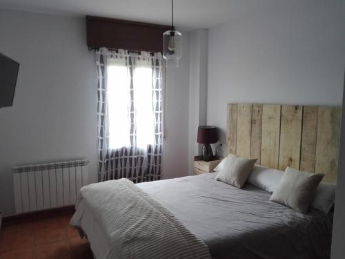 SojuelaVino Montaña & jardín Garaje NETFLIX WIFI INCLUIDO,的一间卧室设有一张大床和一个窗户。