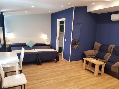 马德里美国大街提吉卡尔公寓式酒店的一间卧室配有一张床、一张沙发和一张桌子