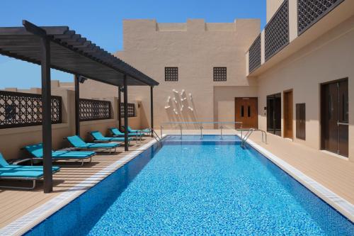 迪拜Hyatt Place Dubai Wasl District Residences的一个带躺椅的游泳池和一个泳池景