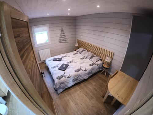 阿莱蒙Chalet de l'Oisans的一间小房间的卧室,配有一张床铺