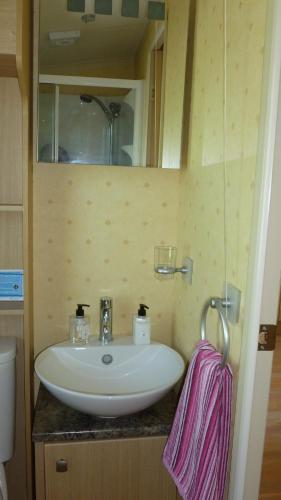 康福斯28 Borwick Lakes的浴室设有白色水槽和镜子