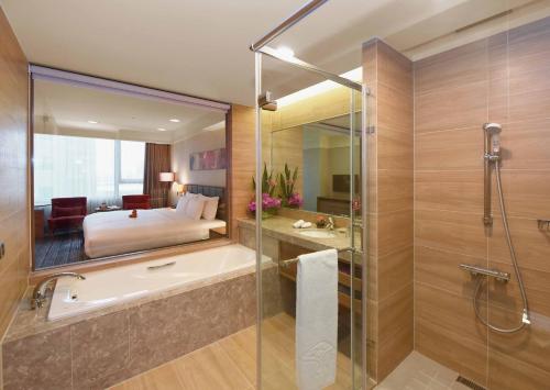 龟山乡福容大饭店桃园机场捷运A8的带浴缸的浴室和卧室