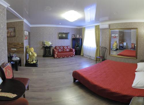 尼古拉耶夫Міні-готель Пекін的一间卧室配有红色的床和一张沙发
