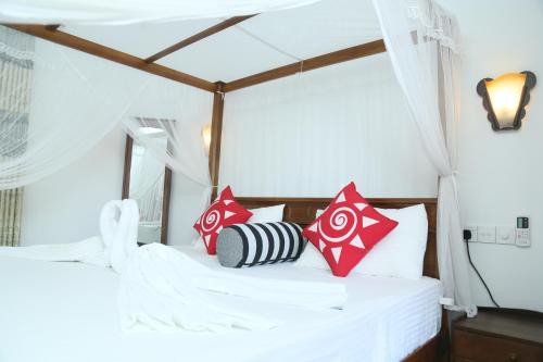 肯克拉Villa Koggala的一间卧室配有红色和白色枕头的床