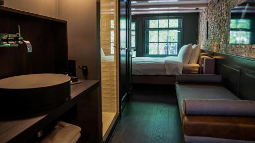 阿姆斯特丹Hotel Frank since 1666的一间带水槽的浴室和一间带一张床的卧室