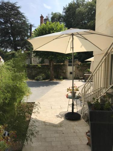 罗什科尔邦Chambre Troglodytique Villa Marie Louise的一把伞坐在楼梯旁的庭院
